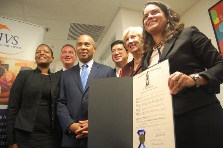 The Massachusetts Immigrant Entrepreneurship Month proclamation is held up by Josiane Martinez, executive director of the Office for Refugees and Immigrants, right. From left are Rep. Linda Dorcena Forry, Rep. Daniel Cullinane, Gov. Deval Patrick, Rep. Tackey Chan and State Senator Eileen Donoghue.