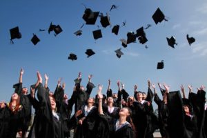 Crowd of graduates tossing their hats in the air