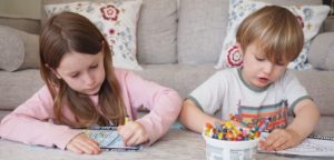 Two children enjoying coloring in our Drawing Support pages.