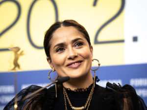 Salma Hayek sitting behind a microphone