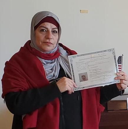 The ILC student Muna holding her citizenship certificate