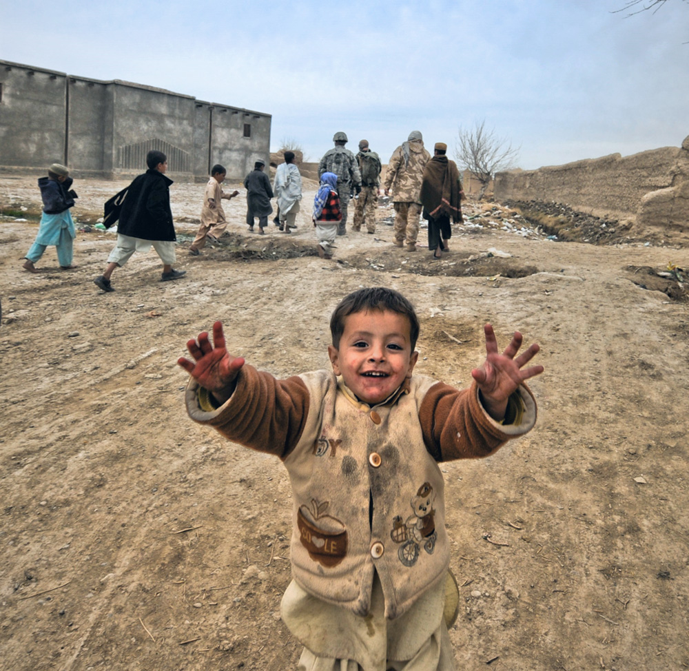 An Afghan boy greets U.S. soldiers from B Flight, 27 Squadron, Royal Air Force Regiment during a dismounted patrol in Kvoshab Village near Kandahar Airfield, Afghanistan.