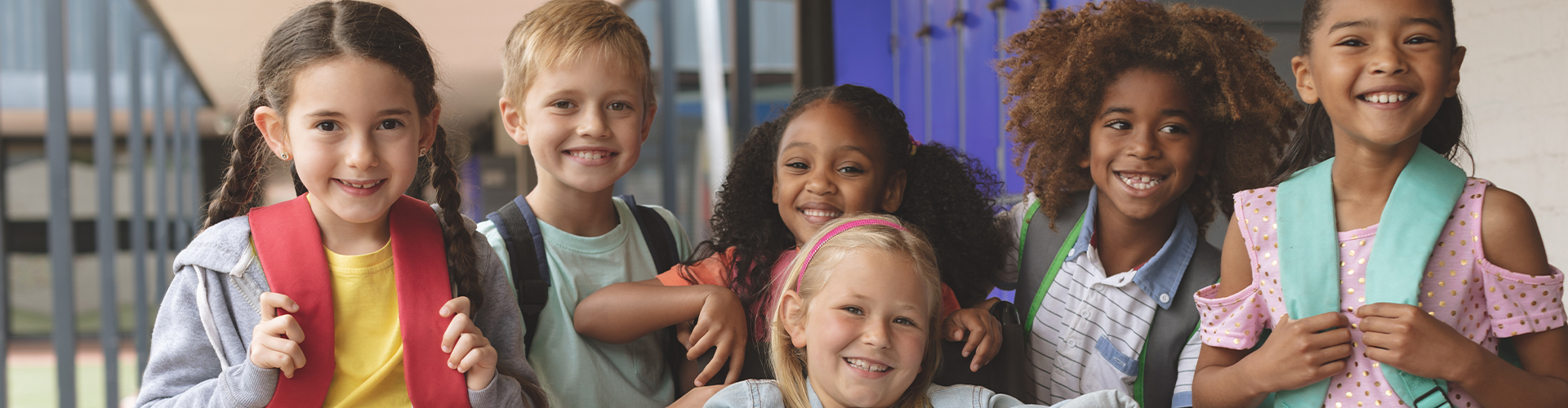 A diverse group of elementary school-age children smiling for the camera.