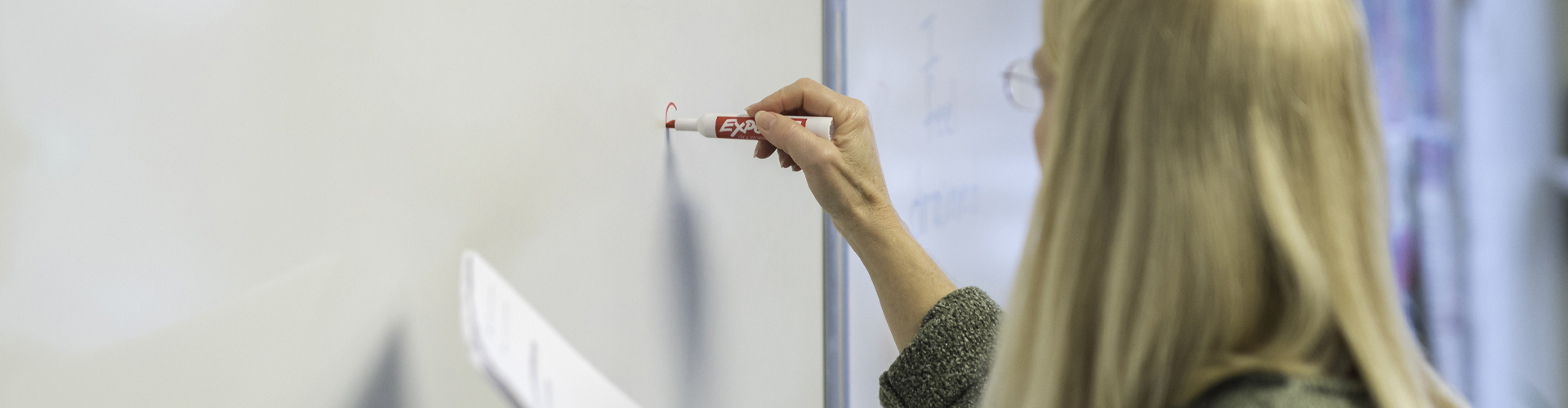 ESL teacher writing on classroom whiteboard using immigration lesson plans and resources