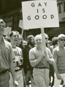 A group of Mattachine Society members picketing. One is holding up a sign that says, "Gay is good."
