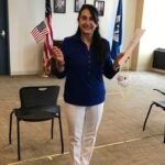 Mariagrazia holding an American flag after becoming a citizen