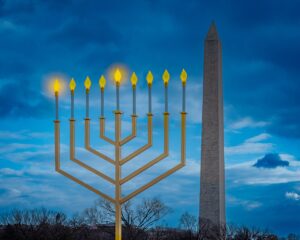 The large National Menorah with all nine flames lit up in front of the Washington monument.