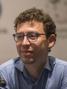 A close-up photo of Luis von Ahn. He's wearing glasses and looking off to the side.