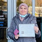 Amani holding her citizenship certificate