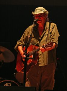 Neil Young playing the guitar in a concert