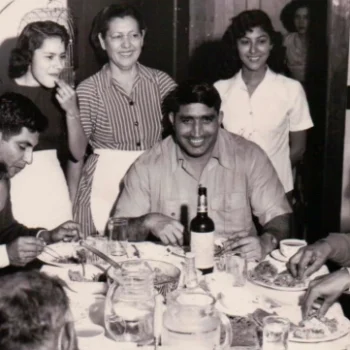 Tiger Joginder Singh at a packed dinner table surrounded by other people.