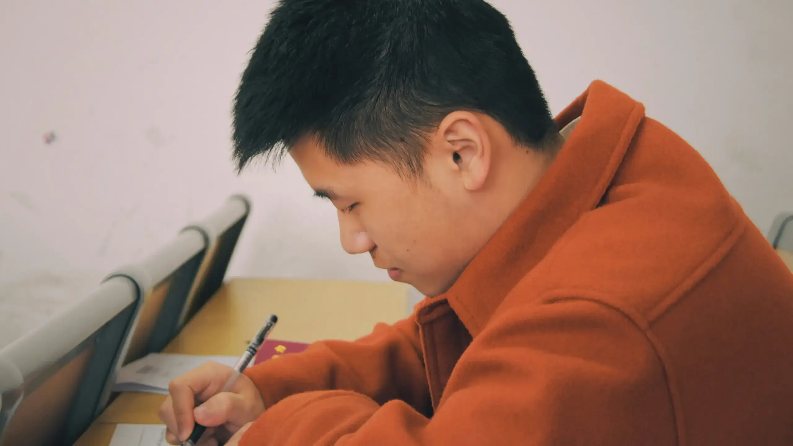 An Asian man at a desk taking a test.